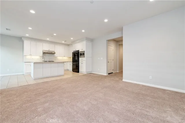 a kitchen with kitchen island granite countertop a stove a sink and a refrigerator