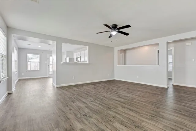 a view of empty room with wooden floor and window
