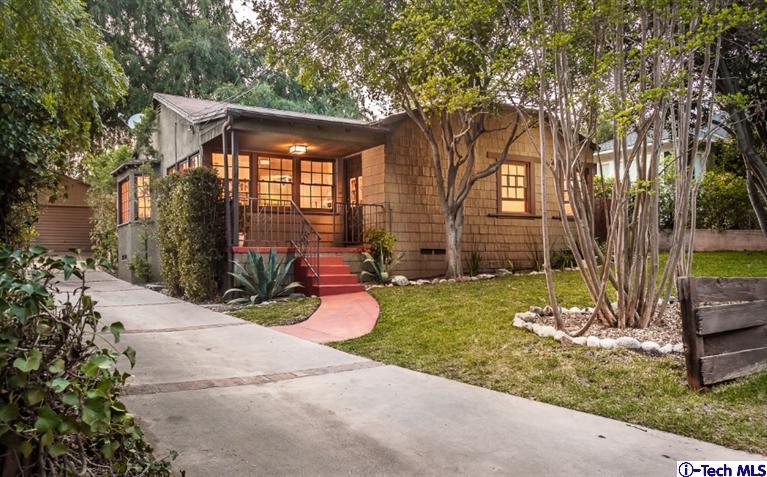 a view of a house with backyard and a tree