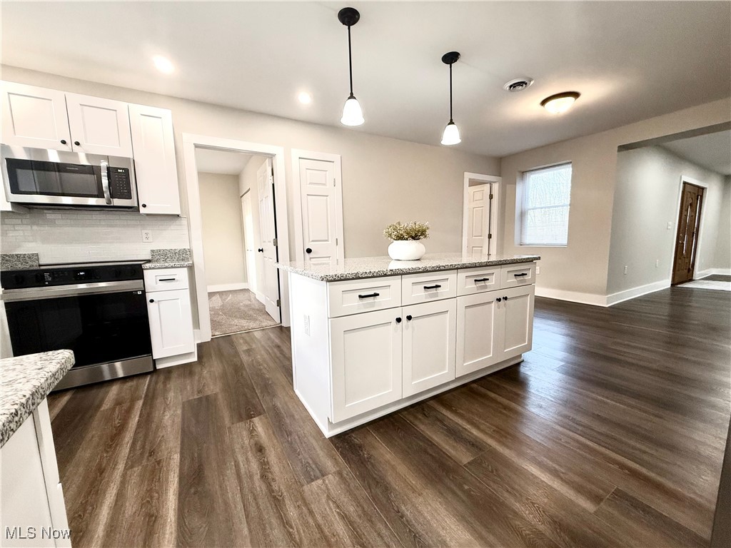 4670 Sandy Lake Road Ravenna, OH 44266 - Photo 10 of 26 Kitchen featuring white cabinetry, electric range, and stainless steel microwave