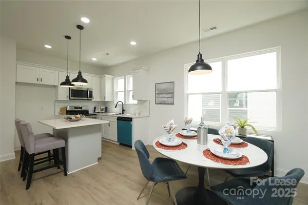 a kitchen with a dining table and chairs