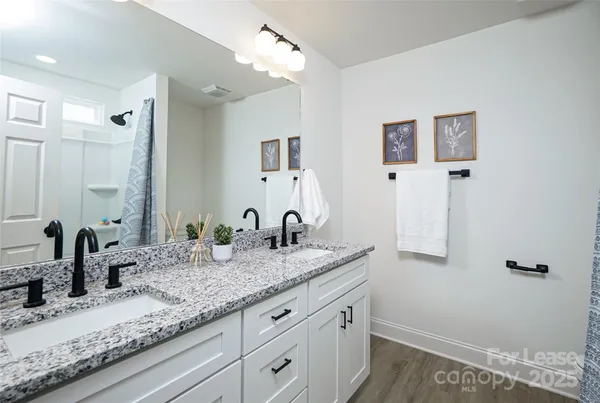 a bathroom with a granite countertop sink and a mirror
