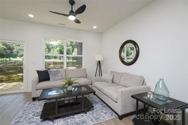 a living room with furniture a large window and a table