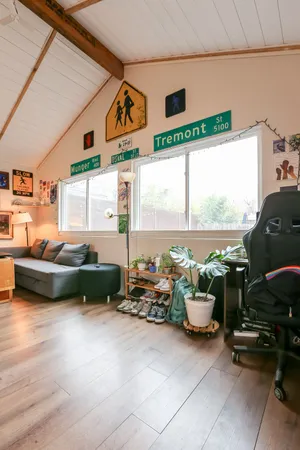 a living room with furniture a flat screen tv and a large window