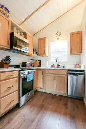 a kitchen with stainless steel appliances a stove microwave and sink