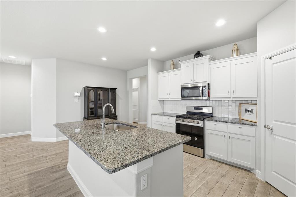 1420 Pleasanton Road Cleburne, TX 76033 - Photo 12 of 39 a kitchen with stainless steel appliances granite countertop a sink stove and refrigerator