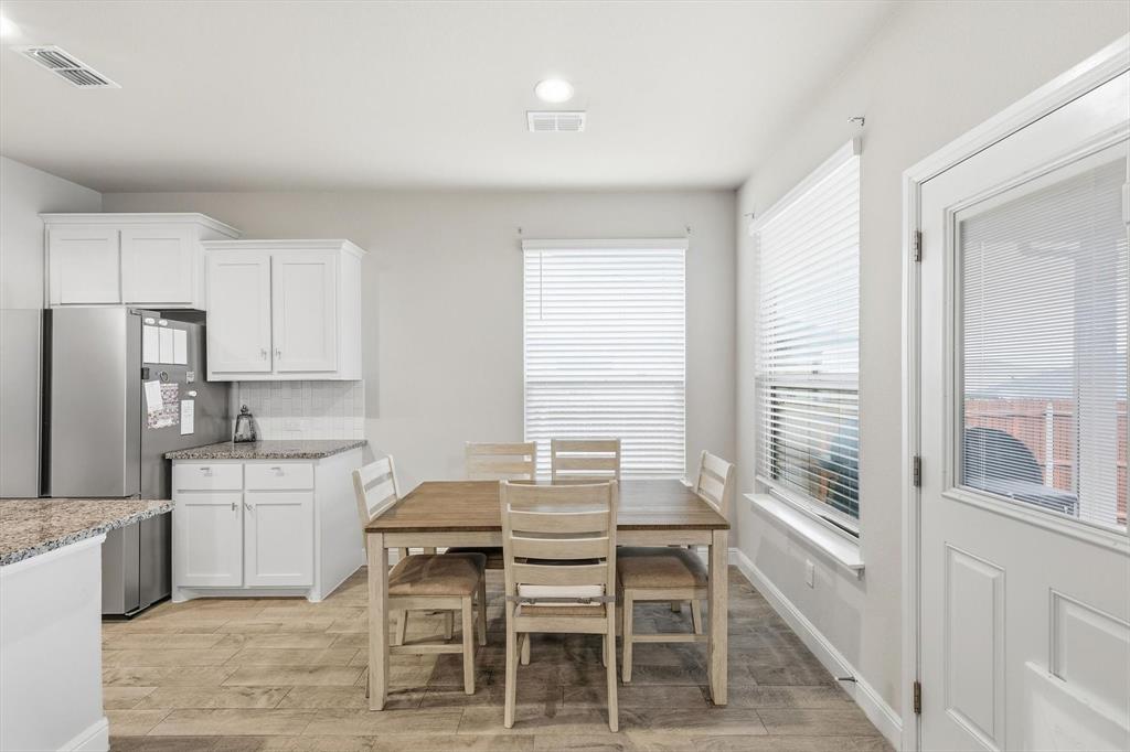 1420 Pleasanton Road Cleburne, TX 76033 - Photo 14 of 39 a kitchen with a table chairs refrigerator and cabinets