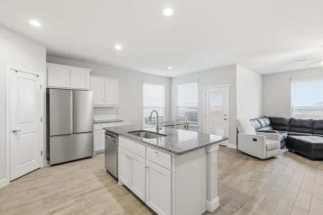 a kitchen with stainless steel appliances granite countertop a sink stove microwave and refrigerator