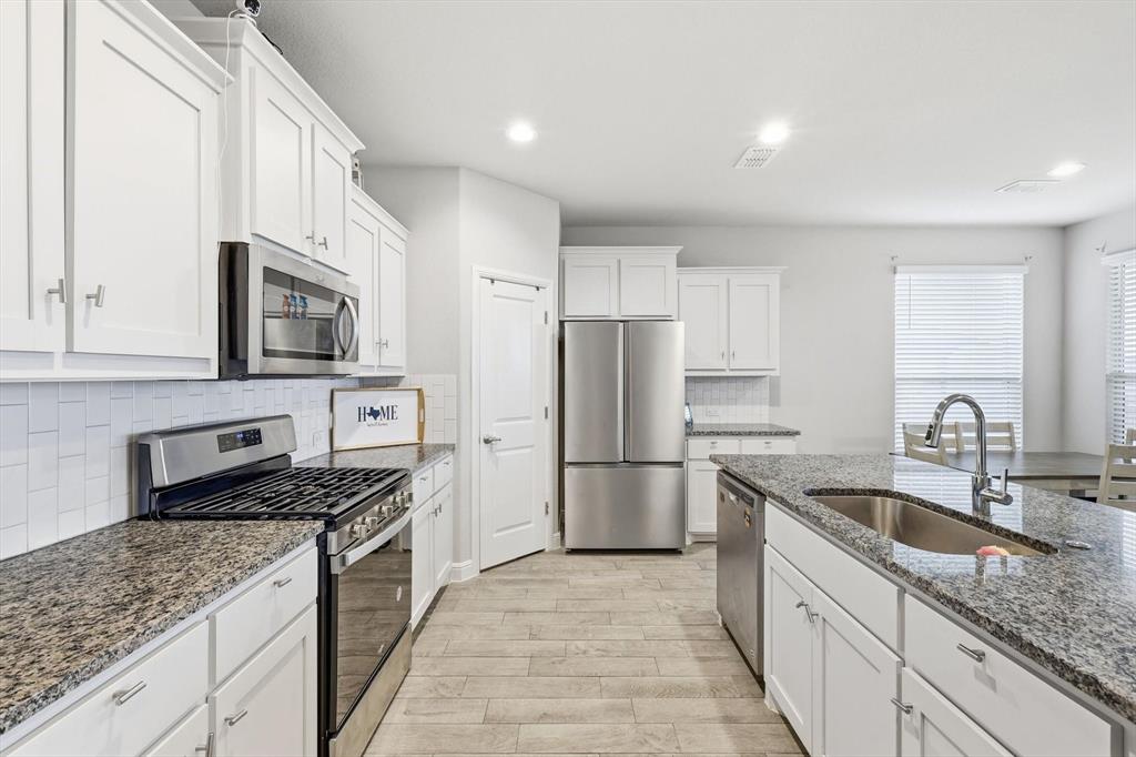 1420 Pleasanton Road Cleburne, TX 76033 - Photo 9 of 39 a kitchen with stainless steel appliances granite countertop a sink stove microwave and refrigerator