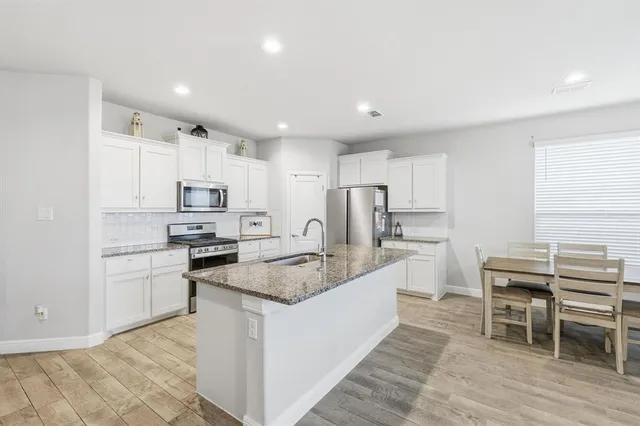 a kitchen with stainless steel appliances granite countertop a refrigerator a sink a stove a microwave and island