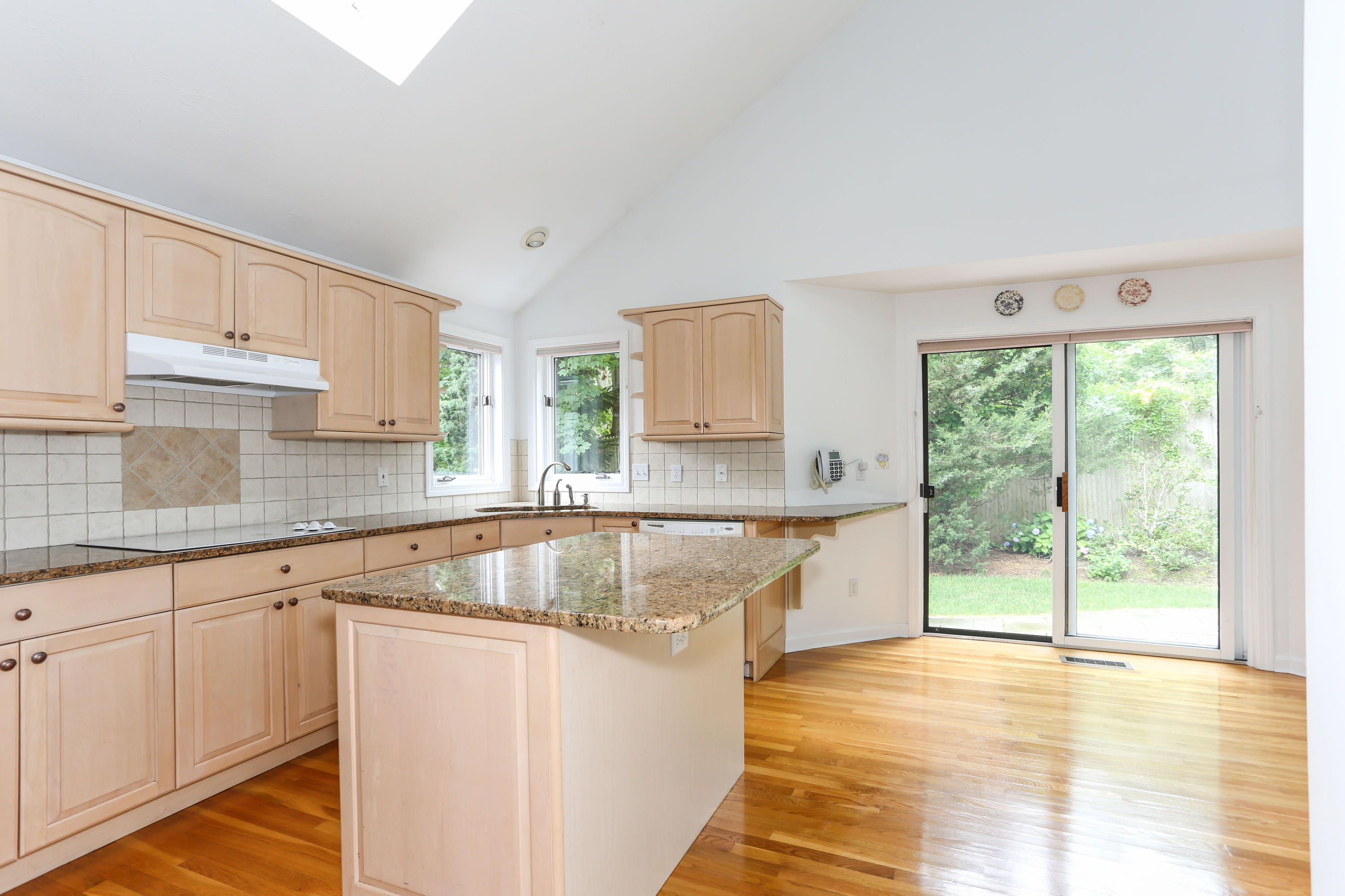 65 Trinity Place Centerville, MA 02632 - Photo 11 of 34 a kitchen with stainless steel appliances granite countertop a stove a sink and white cabinets