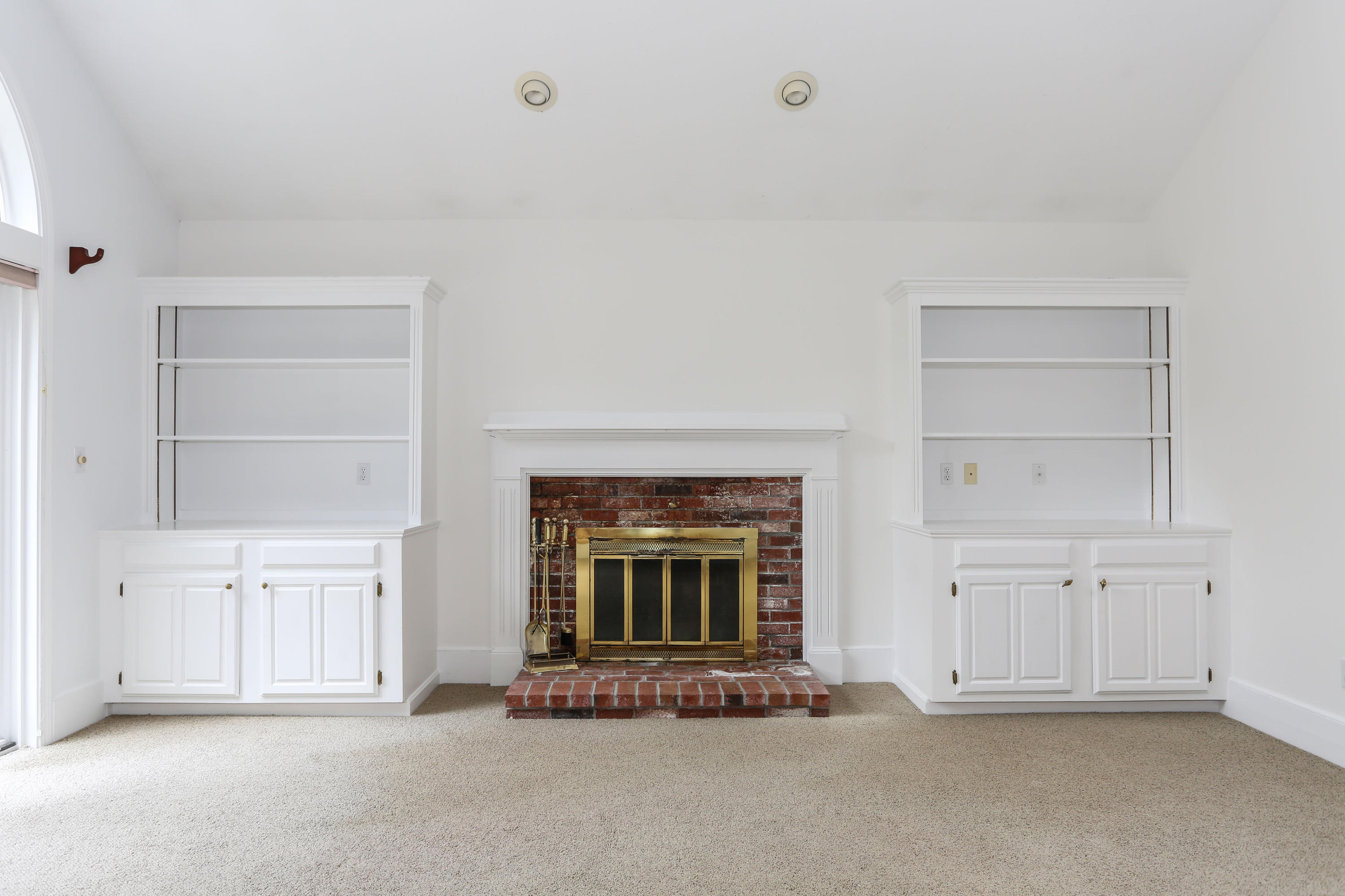 65 Trinity Place Centerville, MA 02632 - Photo 13 of 34 a view of an empty room with a fireplace and cabinets