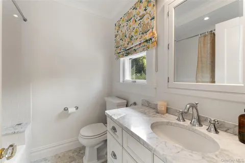 a bathroom with a granite countertop sink mirror vanity and toilet