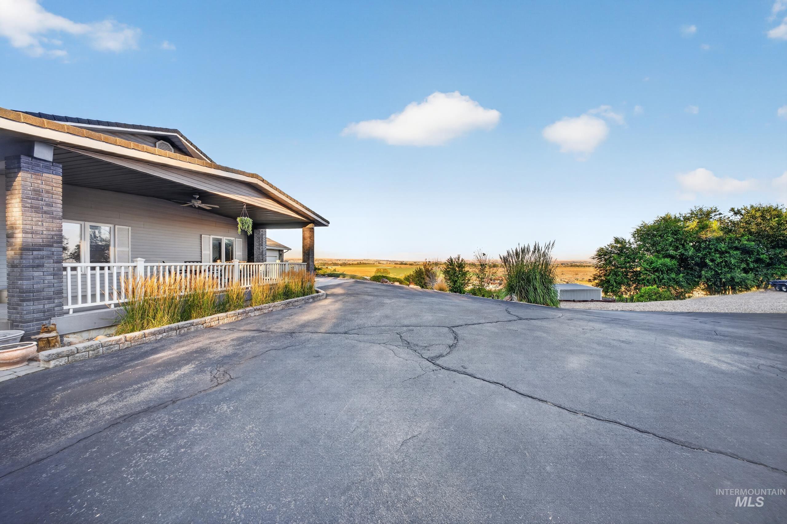 5540 Finley Road Fruitland, ID 83619 - Photo 17 of 50 Charming brick residence with a covered front porch featuring white railings, situated on a spacious asphalt driveway