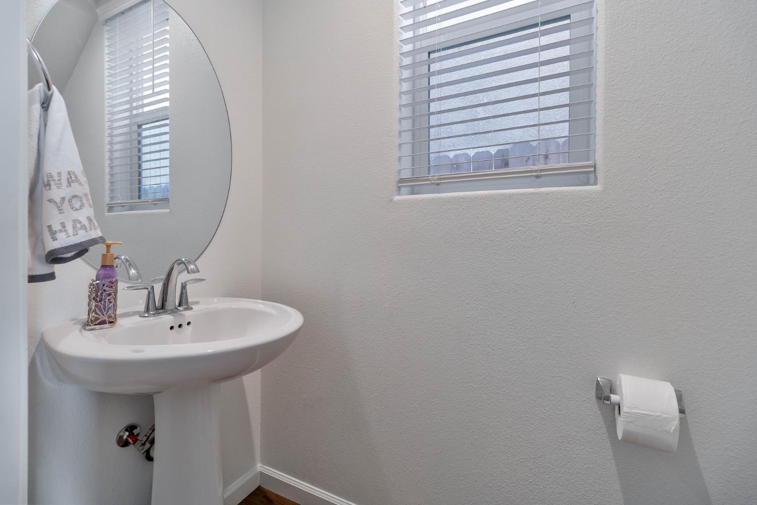 915 Winchell Way West Madera, CA 93636 - Photo 14 of 42 a bathroom with a sink a mirror and a window