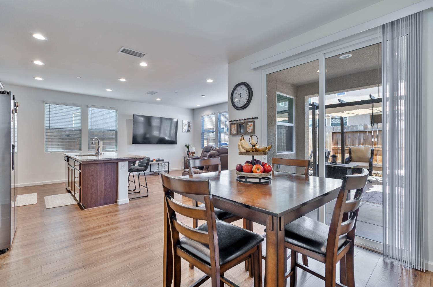 915 Winchell Way West Madera, CA 93636 - Photo 15 of 42 a dining area with stainless steel appliances kitchen island granite countertop a dining table chairs and stove top oven with wooden floor