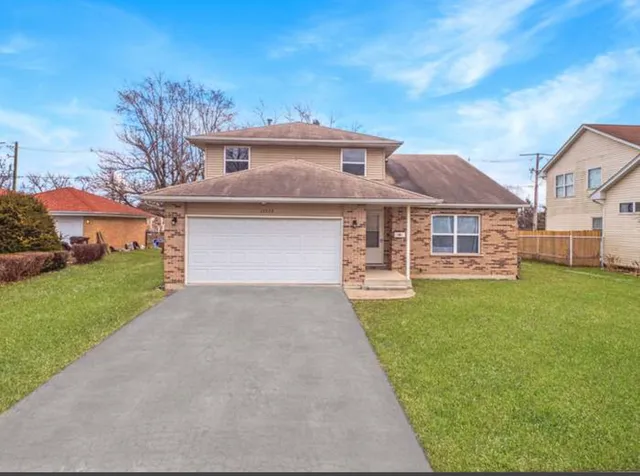 a front view of a house with a yard and garage