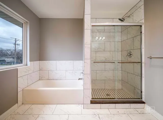 a bathroom with a bathtub and shower