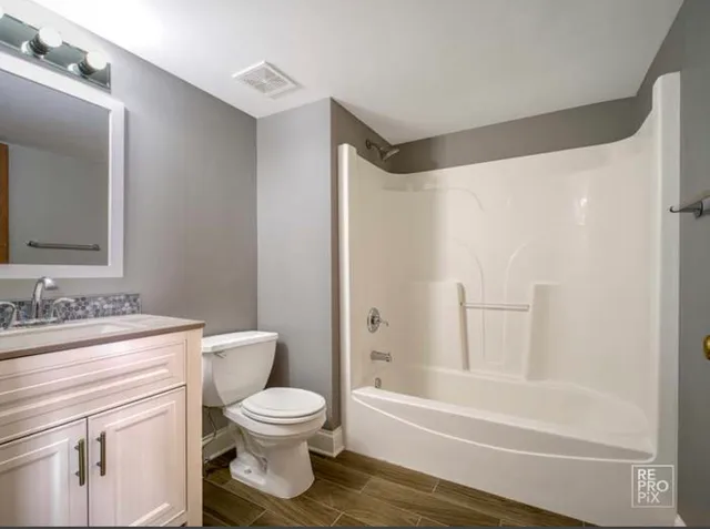 a bathroom with a granite countertop toilet a sink and a bathtub