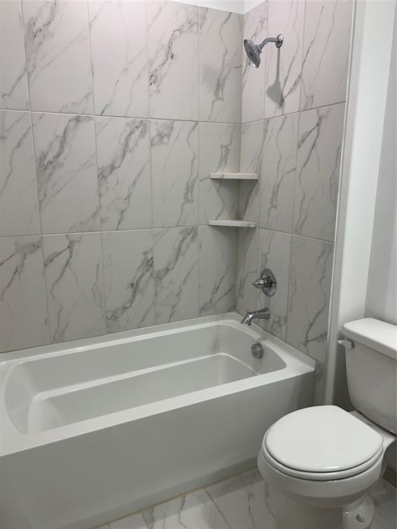 6041 Roper Road McKinney, TX 75070 - Photo 10 of 24 Bathtub and shower combination featuring white marble-look tile surround and chrome fixtures
