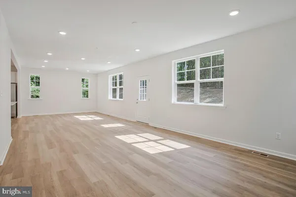 a view of empty room with wooden floor and windows