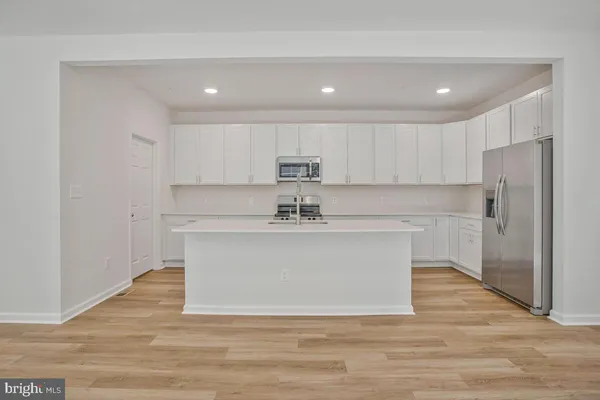 a view of kitchen with stainless steel appliances granite countertop a white stove top oven and refrigerator