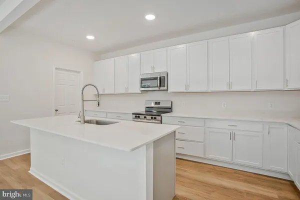 a kitchen with sink a microwave and cabinets