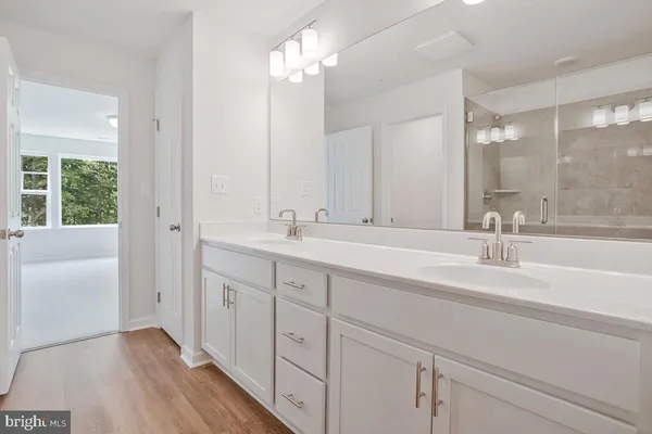 a bathroom with double vanity and a mirror