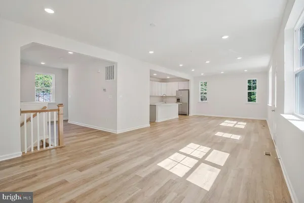 a view of empty room with wooden floor and windows