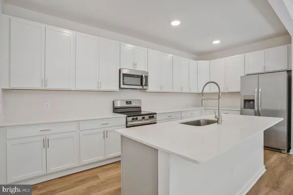 a kitchen with appliances a sink and cabinets