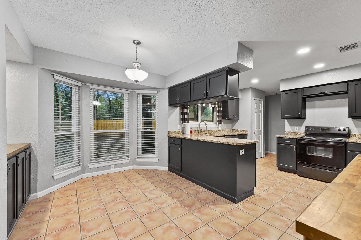 3702 Ember Spring Drive Houston, TX 77339 - Photo 12 of 27 a kitchen with stainless steel appliances kitchen island granite countertop a stove top oven a sink dishwasher a dining table and chairs with wooden floor