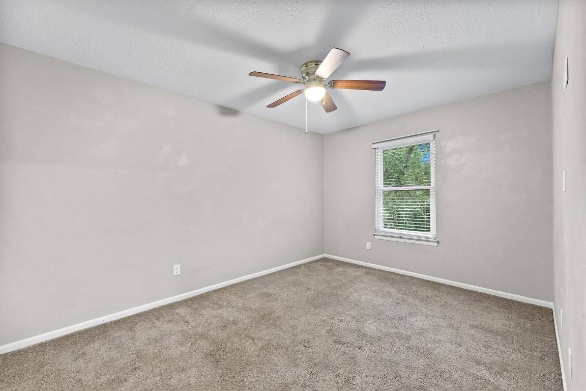3702 Ember Spring Drive Houston, TX 77339 - Photo 23 of 27 an empty room with a window and ceiling fan