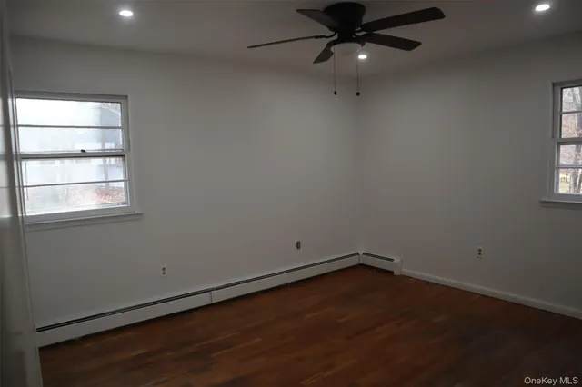 an empty room with a window and ceiling fan