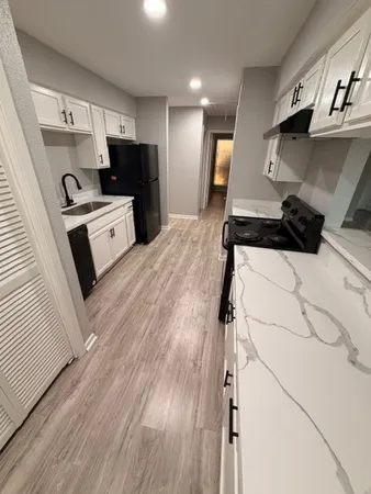 a kitchen with stainless steel appliances kitchen island wooden floors wooden cabinets and view