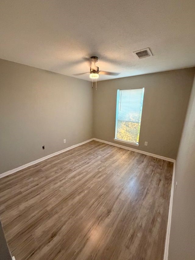 2955 Shadow Trail Drive Houston, TX 77082 - Photo 16 of 19 wooden floor in an empty room with a window