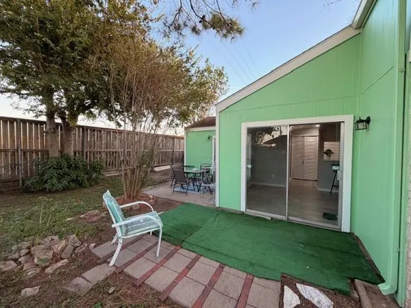 a view of a backyard with chairs potted plants and wooden fence