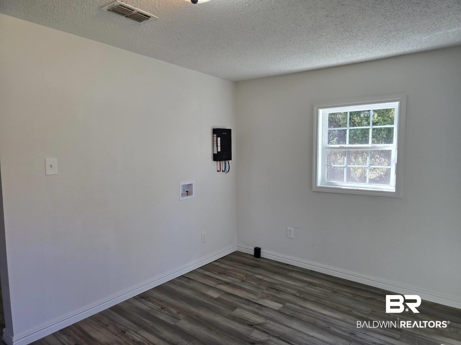 821 Dailey Street Brewton, AL 36426 - Photo 17 of 17 Spare room with dark wood-style flooring and a textured ceiling