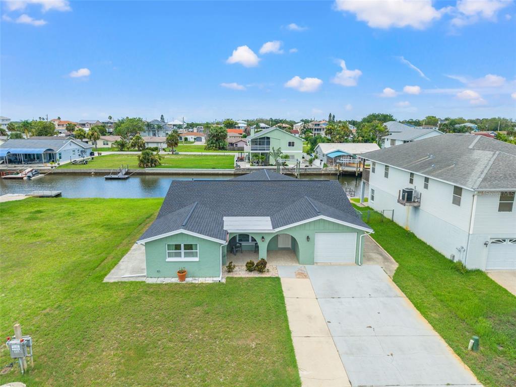 a aerial view of a house with a yard basket ball court and outdoor seating