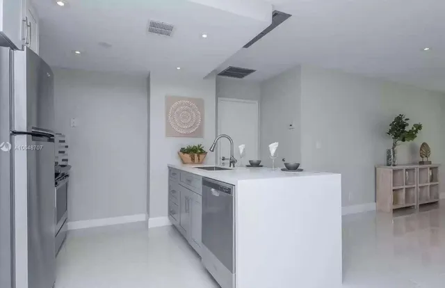 a kitchen with a sink and refrigerator