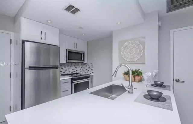 a kitchen with a refrigerator and a stove top oven
