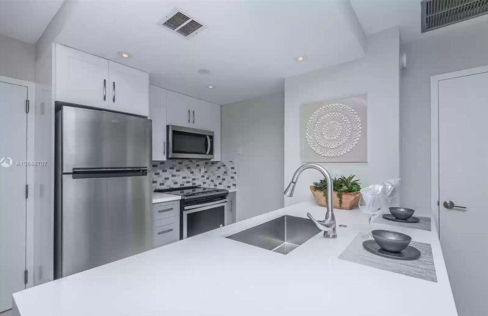 3212 Northeast 12th Street, Unit 302 Pompano Beach, FL 33062 - Photo 14 of 25 a kitchen with a refrigerator and a stove top oven