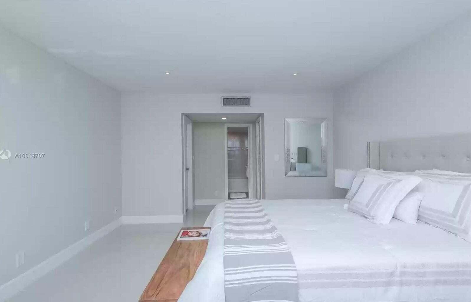 3212 Northeast 12th Street, Unit 302 Pompano Beach, FL 33062 - Photo 23 of 25 a spacious bedroom with a bed and mirror