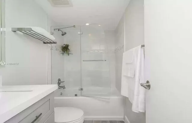 a bathroom with a bathtub shower sink vanity and toilet