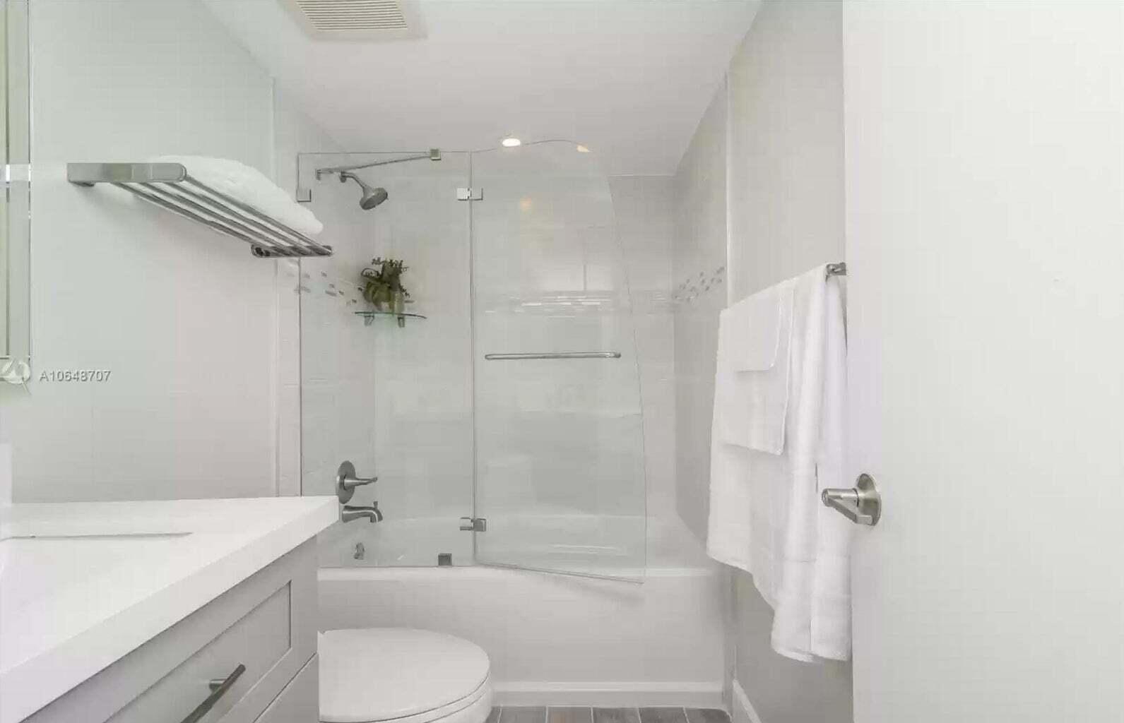 3212 Northeast 12th Street, Unit 302 Pompano Beach, FL 33062 - Photo 8 of 25 a bathroom with a bathtub shower sink vanity and toilet