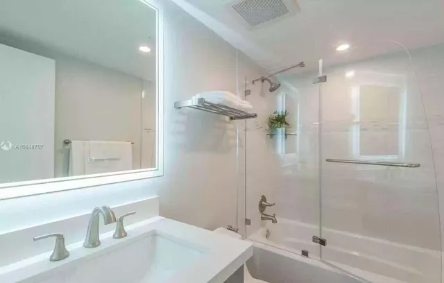 a bathroom with a tub sink and mirror