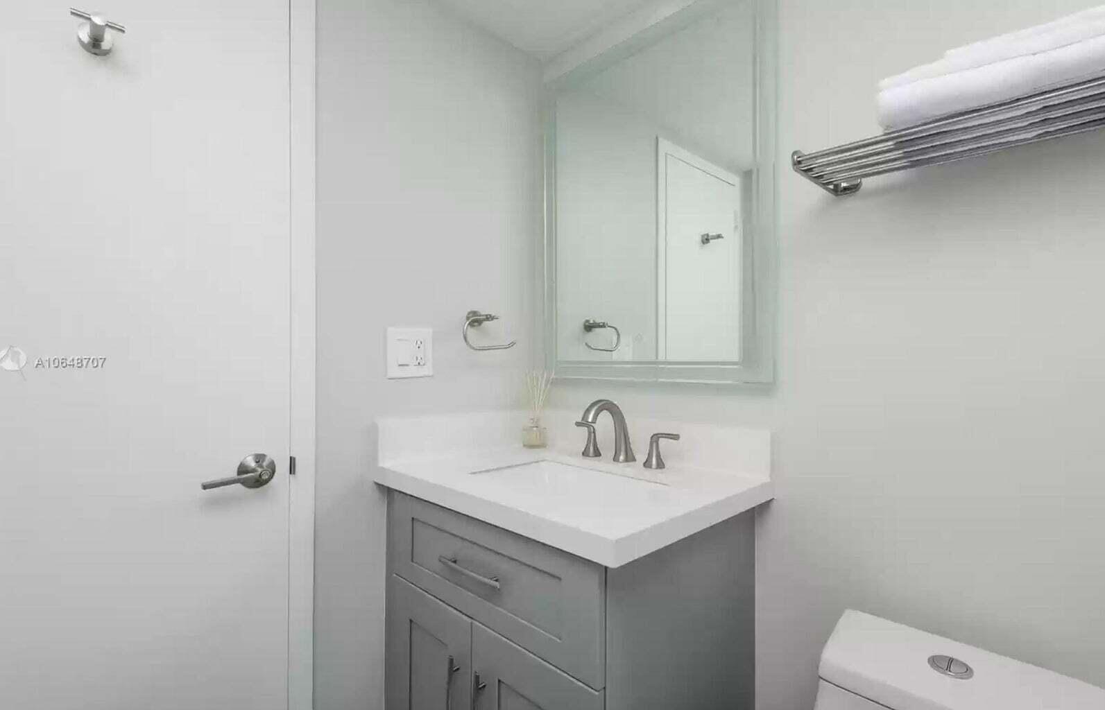 3212 Northeast 12th Street, Unit 302 Pompano Beach, FL 33062 - Photo 10 of 25 a bathroom with a sink toilet and mirror