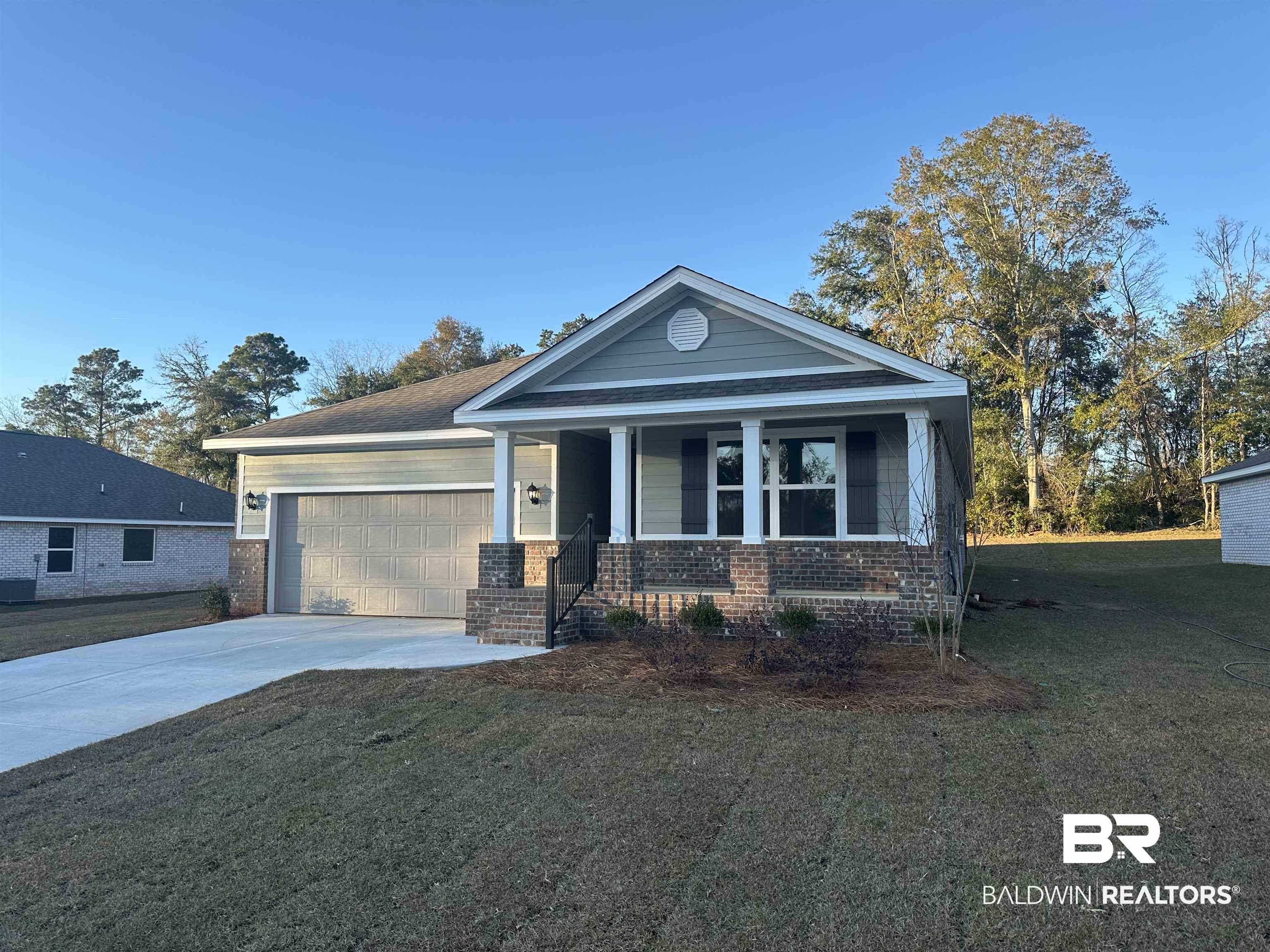 16252 Laurelbrooke Loop Fairhope, AL 36532 - Photo 1 of 28 View of front of property featuring covered porch, a garage, and a front lawn