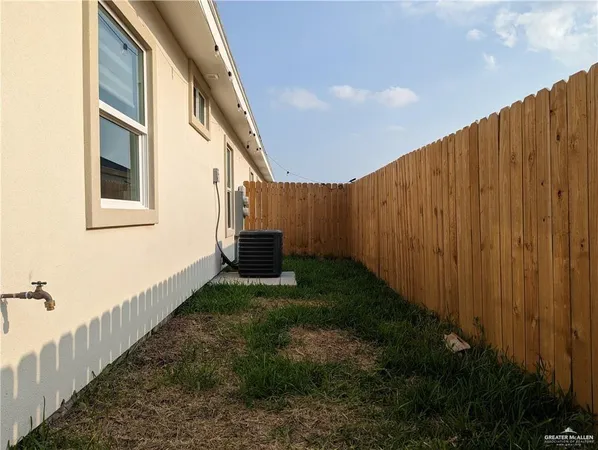a view of backyard with barbeque grill and wooden fence