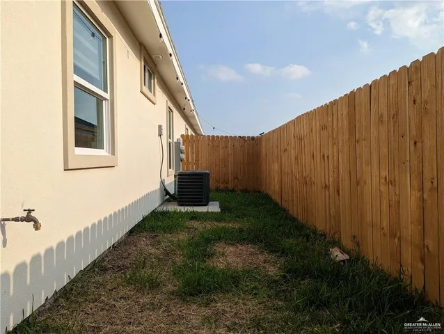 a view of backyard with barbeque grill and wooden fence