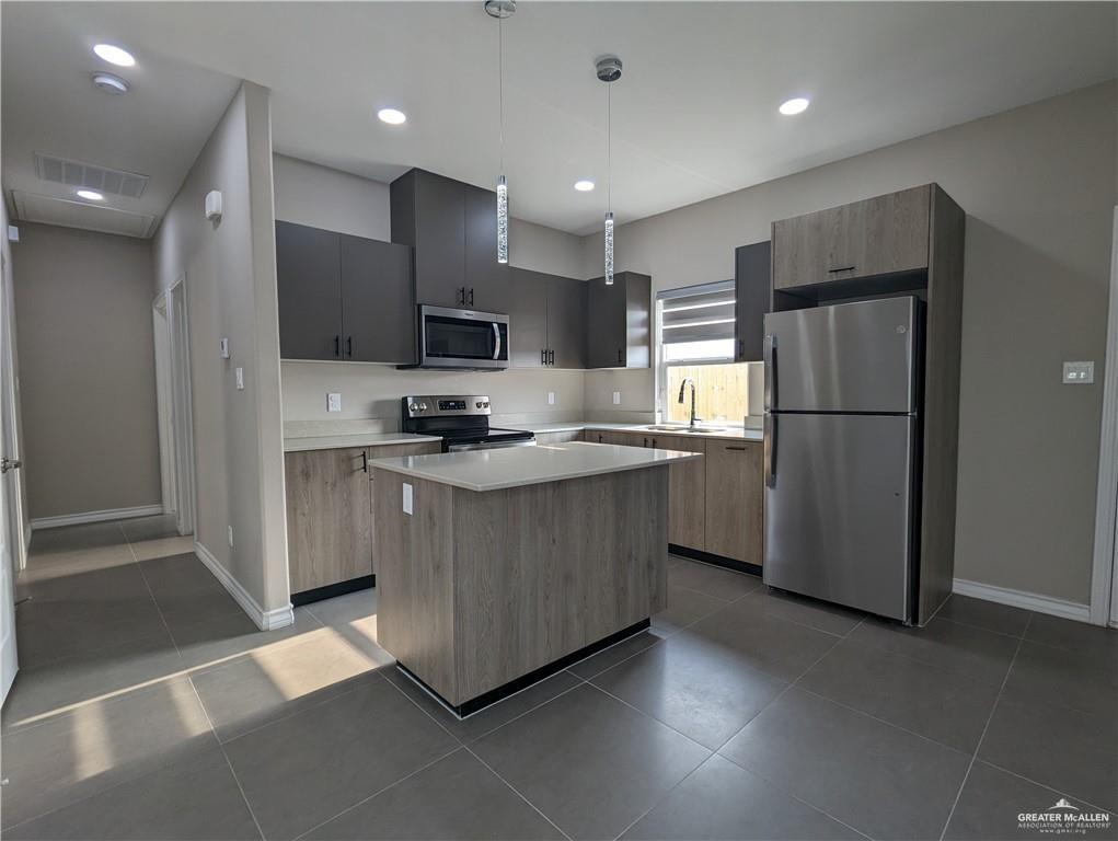 5905 Puffin Avenue, Unit 1 Mission, TX 78573 - Photo 4 of 12 a kitchen with stainless steel appliances granite countertop a refrigerator sink and cabinets